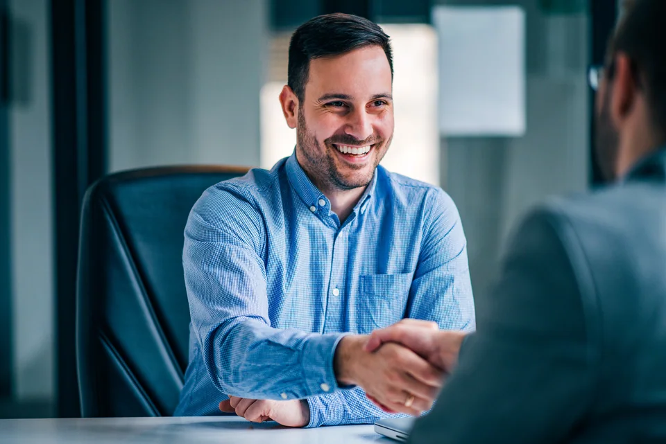 A handshake during a business meeting at a desk
